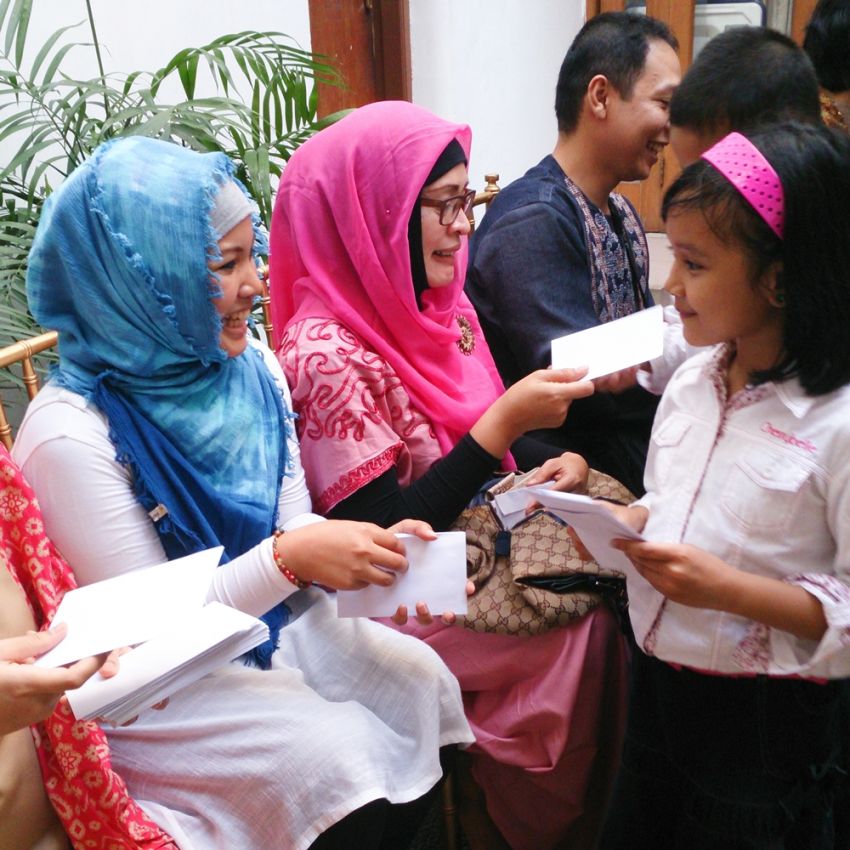 Child receiving Salam Tempel from her adult family members