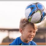 hildren heading ball while playing football