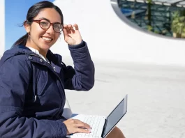 Cheerful young woman eyeglasses using laptop and tips to be smarter