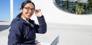 Cheerful young woman eyeglasses using laptop and tips to be smarter